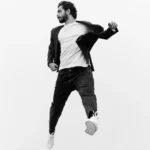 مردی در حال پرش با ژاکت مشکی و شلوار جین، کافه ترانه، آهنگ جدید